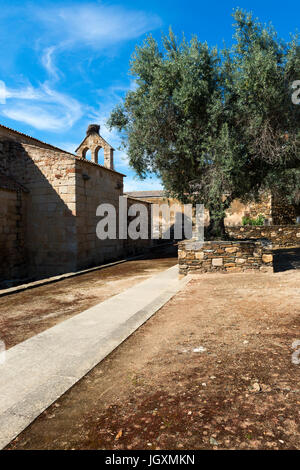 Dettaglio di una vecchia chiesa e un albero di olivo nel villaggio storico di Idanha a Velha in Portogallo; concetto per il viaggio in Portogallo Foto Stock