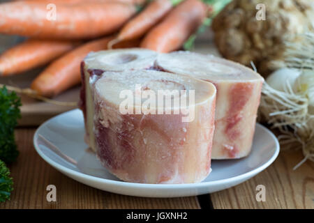 Ingredienti per la realizzazione di un osso di manzo in brodo - ossibuchi, carote, cipolle, sedano radice Foto Stock