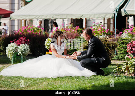 Fantastico matrimonio giovane seduto sul prato di uno splendido giardino. Foto Stock