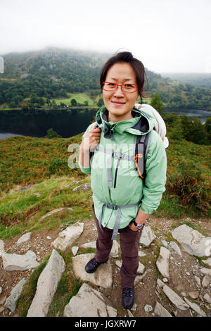 Sorridente East Asian Woman Hiking nel Lake District, Cumbria, Regno Unito. Foto Stock