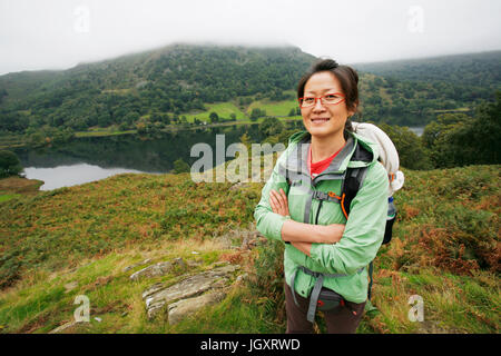 Sorridente East Asian Woman Hiking nel Lake District, Cumbria, Regno Unito. Foto Stock