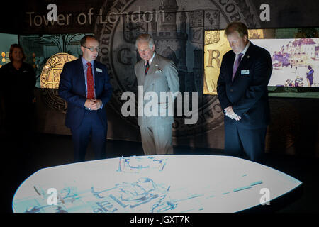 Il Principe di Galles è mostrato un display interattivo dal Direttore della Royal Mint Museum Dr Kevin Clancy, (sinistra) e Royal Mint CEO Adam Lawrence, durante un tour della Royal Mint il centro visitatori di Heol-Y-Sarn, Galles. Foto Stock