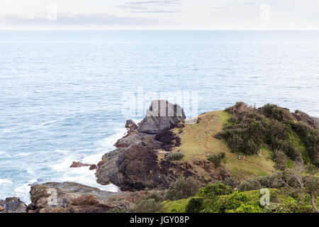 Due persone esplorare distante un sentiero litorale su un bellissimo promontorio erboso dall'Oceano Pacifico vicino a Port Macquarie, Australia. Foto Stock