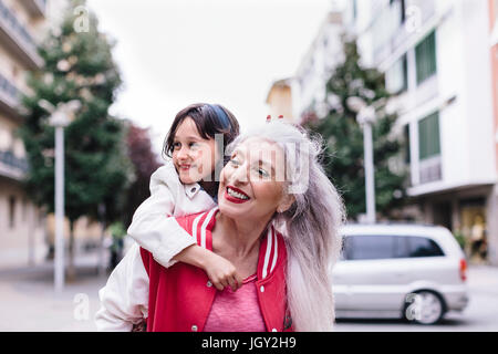 Donna matura dando ragazza sovrapponibile in città Foto Stock