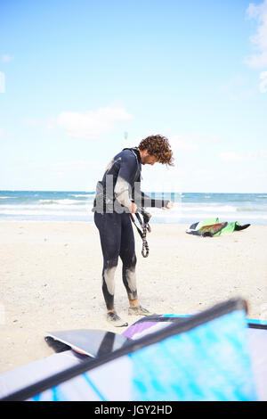 Kite surfer facendo preparativi sulla spiaggia, Hornbaek, Hovedstaden, Danimarca Foto Stock