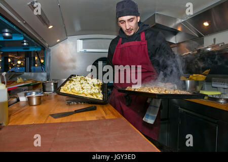 Lo chef prepara le pizze in stallo alimentare van di notte Foto Stock