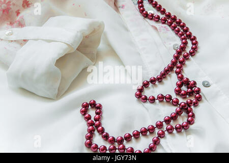 Red collana di perle sulla camicia di seta Foto Stock