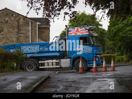 Un ribaltabile (UK) parcheggiata all'entrata di una strada laterale. La strada è bloccata mentre resurfacing stava succedendo. Foto Stock