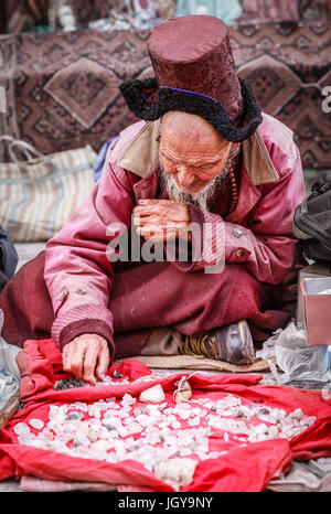 Leh, Ladakh, India, luglio 12, 2016: locale l uomo è la vendita di cristalli sul marciapiede in un mercato di Leh, Ladakh distretto dello stato del Kashmir, India Foto Stock