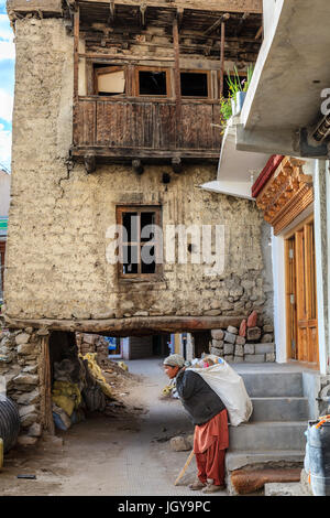 Leh, Ladakh, India, luglio 12, 2016: una donna locale che trasportano borsa pesante con l'immondizia in una zona residenziale di Leh, Ladakh distretto dello stato del Kashmir, India Foto Stock