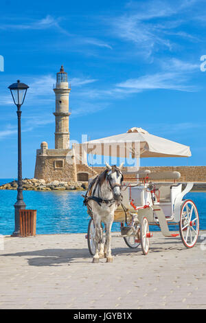 Carrozza a cavallo sul Porto Veneziano, faro in background, Chania, Creta, Grecia Foto Stock