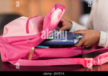 La scolaretta zaino di imballaggio e preparazione per la scuola, scuola elementare concetto dello studente Foto Stock