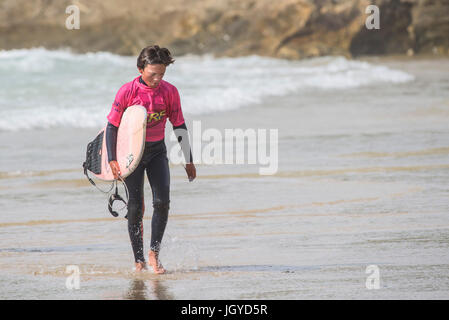 Navigare in UK. Un molto stanco giovane maschio surfer passeggiate fuori del mare dopo la concorrenza nel Regno Unito scuole surf campionato. Nerf scontro di Groms a Fis Foto Stock