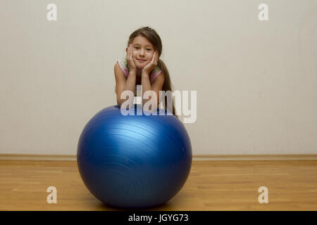 Positivo bambina con la sfera blu. Infanzia felice, moda autunnale concetto dell'umore. Foto Stock