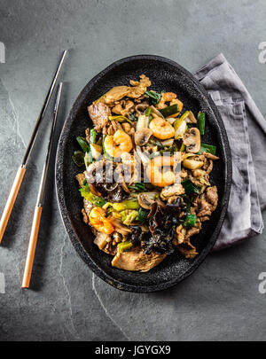 Cibo cinese. Te pam sao. Pan di fritto di manzo, maiale, pollo, gamberi, funghi shitake, champions e cipolline. Parillada di cina servito con riso o Foto Stock