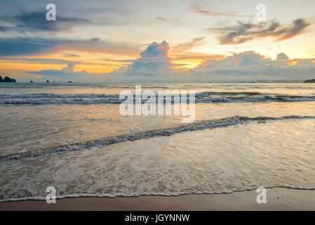 Bel tramonto sul mare di toni di colore arancione e le onde del mare Foto Stock
