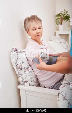 L'infermiera la misura della pressione del sangue di donna senior Foto Stock