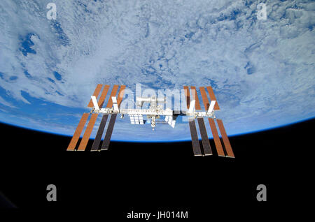 Sospesa e backdropped dalla nerezza di spazio contro il blu della terra si trova la stazione spaziale internazionale. Questa immagine della stazione è stata presa come STS-119 eseguita a volare intorno dopo il disinserimento. Credito di immagine: la NASA Foto Stock