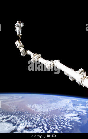 Astronauta Stephen K. Robinson, STS-114 lo specialista di missione, ancorata ad un sistema di ritenuta del piede per l' estensione della Stazione Spaziale Internazionale il Canadarm2, partecipa alla missione della terza sessione di attività extravehicular (EVA). La nerezza di spazio e di terra del modulo di orizzonte lo sfondo per l'immagine. Foto NASA Foto Stock