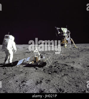 Aldrin guarda indietro al Tranquility Base. Astronauta Edwin E.'' Buzz Aldrin Jr., Modulo Lunare pilota, è fotografato durante la missione Apollo 11 attività extravehicular sulla luna. Egli ha appena distribuito i primi Apollo esperimenti scientifici Package (EASEP). In primo piano è il passivo esperimento sismico Package (PSEP); al di là di esso è il Laser Ranging Retro-Reflector (LR-3); sullo sfondo al centro è gli Stati Uniti bandiera; sullo sfondo a sinistra è il bianco e nero della superficie lunare telecamera. Foto Stock