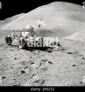 Stoppino colline. David R. Scott, comandante di Apollo 15, lavora presso il Lunar veicolo itinerante (LRV) durante la terza superficie lunare extravehicular attività (EVA) della missione al Hadley-Apennine landing site. La Hadley Rille è al centro a destra dell'immagine. La Hadley Delta, in background, si alza di circa 4 mila metri (circa 13,124 piedi) al di sopra della pianura. San Giorgio cratere è parzialmente visibile a bordo destro superiore. Questa fotografia è stata scattata dal Modulo Lunare pilota James B. Irwin. Questa vista è alla ricerca quasi dovuta a sud. Fotografo: la NASA Foto Stock