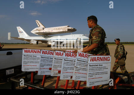 Air Force personale delle forze di sicurezza istituito un perimetro di sicurezza intorno alla navetta spaziale Discovery e della NASA Navetta 747 vettore aereo a Barksdale Air Force Base, La., del 19 agosto 2005. Il 747 e il suo piggy backed scoperta in stato di fermo per una prevista durante la notte il rifornimento di carburante sulla via del ritorno al Centro Spaziale Kennedy, Fla. DoD foto di Master Sgt. Michael A. Kaplan, U.S. Air Force. Foto NASA Foto Stock