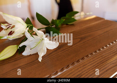 Giglio Fiore sulla bara di legno al funerale nella chiesa Foto Stock