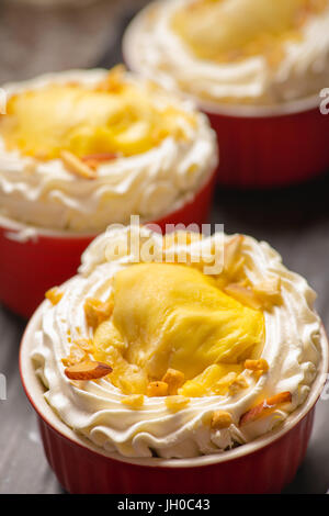 Durian tortine con glassa di formaggio cremoso decorare in rosso cup Foto Stock
