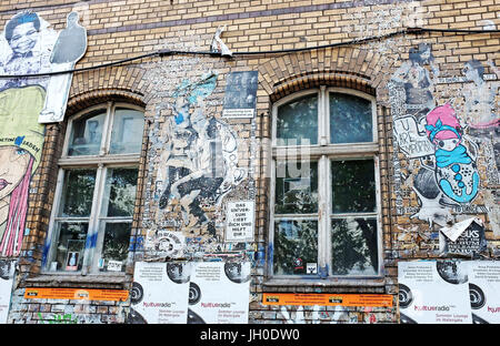 Graffiti arte visualizzato su un edificio di mattoni nel quartiere Kreuzberg di Berlino, Germania canali commento sociale attraverso arte di strada. Foto Stock