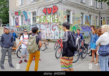 Una gita in bicicletta di gruppo a Berlino, Germania impara circa graffiti da loro Fat Bike Tour guida. Foto Stock