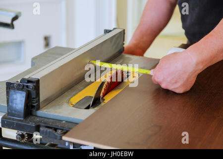 Carpenter utilizzando la tabella visto il taglio di legno. tuttofare di compensato di taglio a sega circolare nella nuova casa Foto Stock