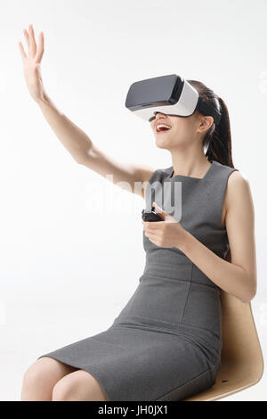 Giovane donna utilizzando la realtà virtuale auricolare Foto Stock