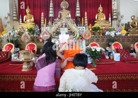 Wat Velouvanaram. Cerimonia buddista. Lao cerimonia buddista con bracciale in cotone. La Francia. Foto Stock