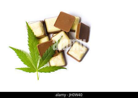 Foglia di Marijuana sulla parte superiore dei pezzetti di cioccolato isolato Foto Stock