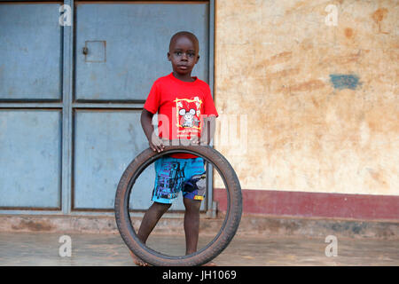 Bambino ugandese giocando con un pneumatico. Uganda. Foto Stock