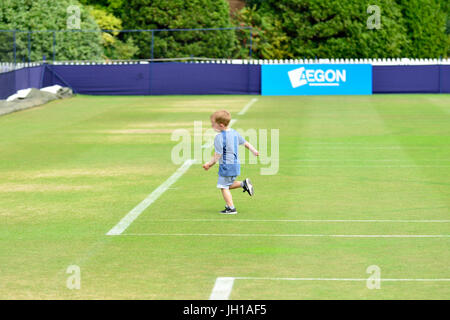 Aegon torneo internazionale di tennis, Devonshire Park, Eastbourne 2017. Giovane ragazzo in esecuzione attraverso la pratica di vuoto giudici di finals giorno Foto Stock