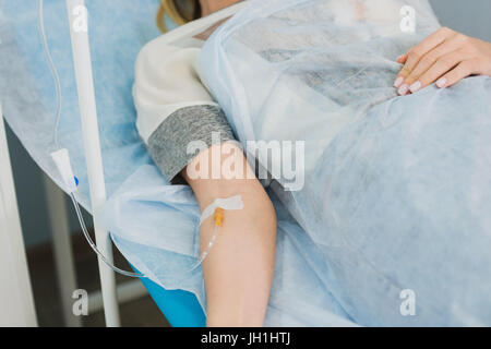 Malinconici donna trasfusa giacente in ospedale Foto Stock