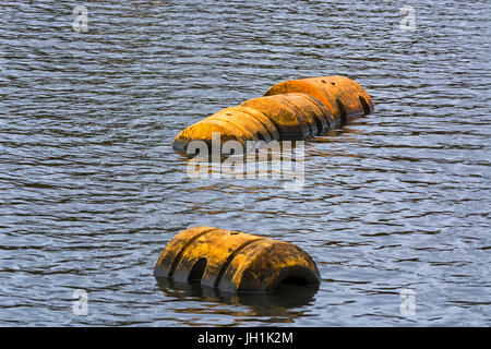 Boa, pipeline o Galleggianti plastici galleggiare sulla superficie dell'acqua. Foto Stock