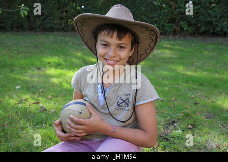 Il 10-anno-vecchio ragazzo tenendo una palla. La Francia. Foto Stock