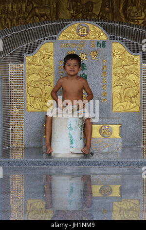 Bambino che gioca in una pagoda di Battambang. Cambogia. Foto Stock