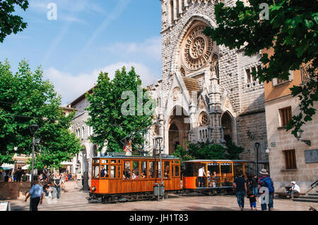 Port de Soller, Mallorca, Spagna - 26 Maggio 2016: il vecchio tram in Soller nella parte anteriore del medievale Duomo gotico con enorme rosone, Mallorca, Spagna Foto Stock