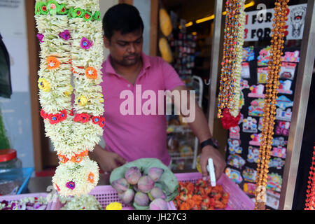 La vendita di fiori, noci di cocco e le altre offerte per la mattina cerimonia puja Singapore. Foto Stock