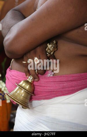 Sacerdote indù. Stretta di mano che tiene il cerimoniale di campana. Singapore. Foto Stock