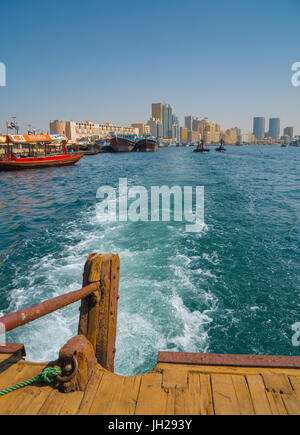 Modern Dubai cityscape scompare nella scia di un vecchio taxi acqueo velocizzando, Dubai, Emirati Arabi Uniti Foto Stock