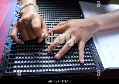 Il Vietnam. Centro per i bambini ciechi. Ragazza scrittura braille. Foto Stock