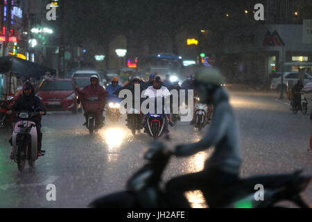 Forti piogge monsoniche. Scooters su Saigon Street. Il Vietnam. Foto Stock