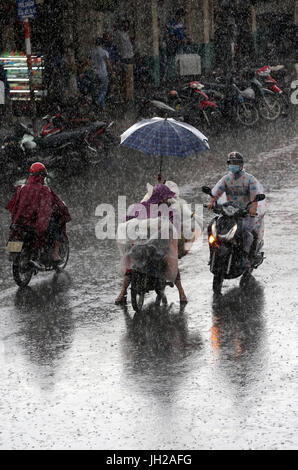 Forti piogge monsoniche. Scooters su Saigon Street. Il Vietnam. Foto Stock