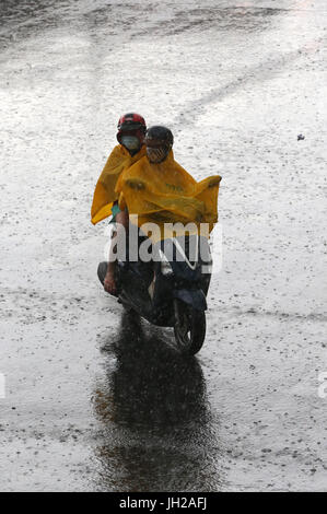 Forti piogge monsoniche. Scooter a Saigon Street. Il Vietnam. Foto Stock