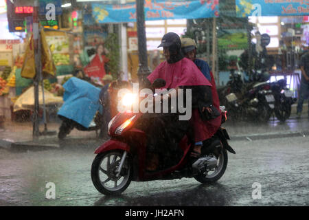 Forti piogge monsoniche. Scooter a Saigon Street. Il Vietnam. Foto Stock