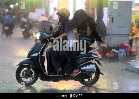 Forti piogge monsoniche. Scooter a Saigon Street. Il Vietnam. Foto Stock